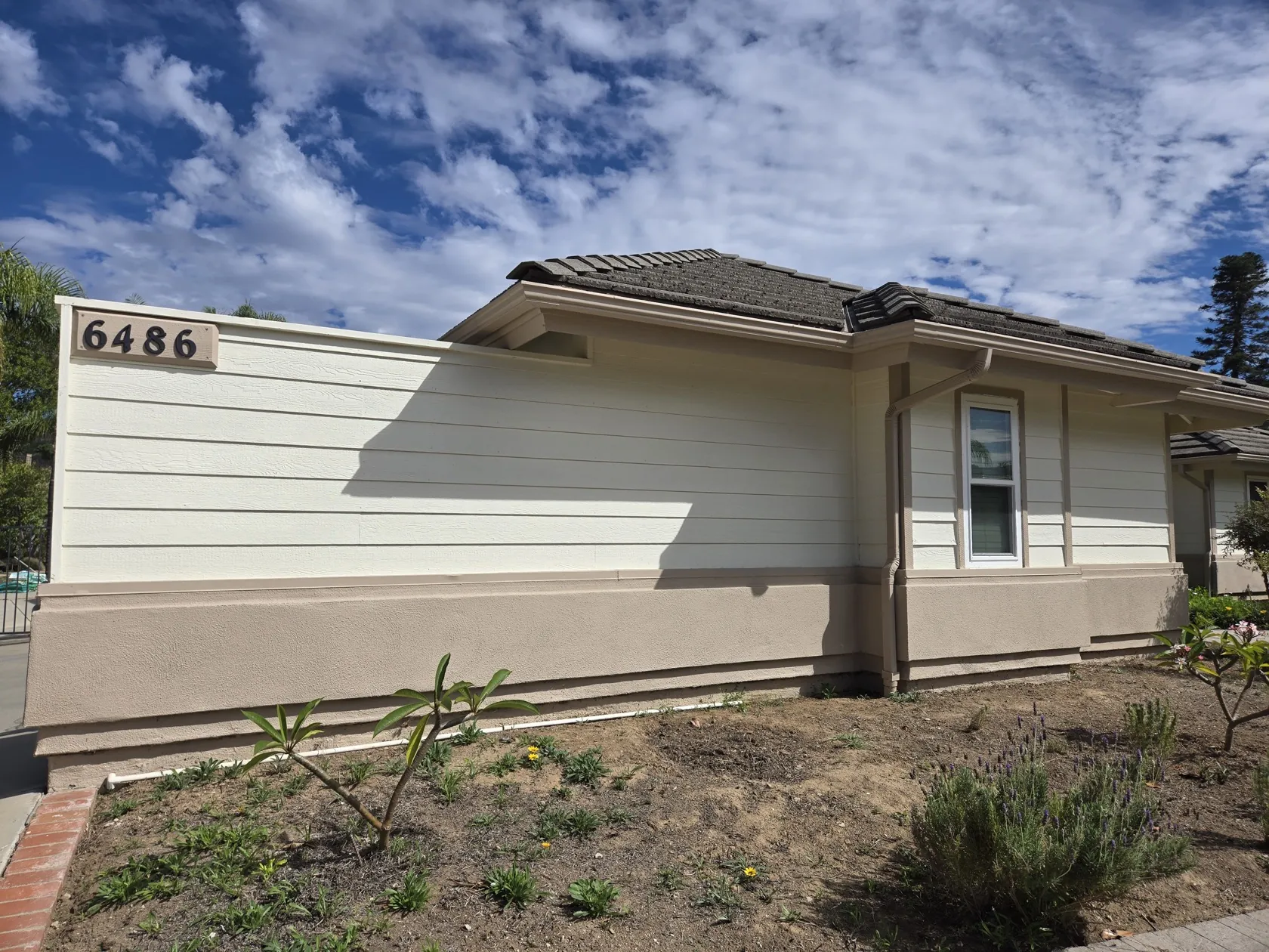Front corner wall with house number, eaves and downspout